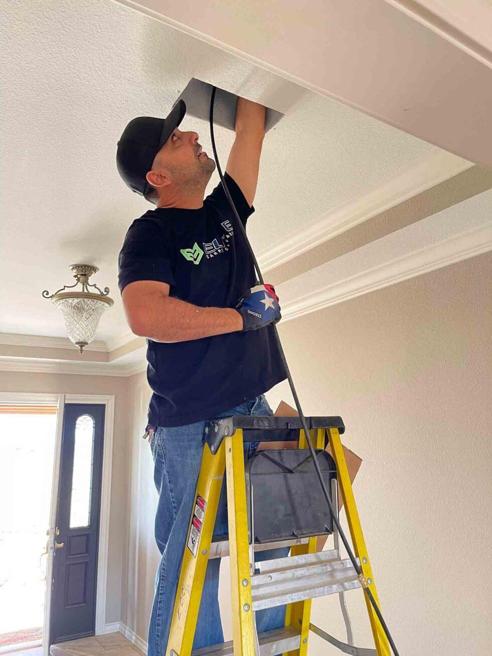 Elite Carpet Cleaning technician performing air-duct service in an Odessa, Texas home